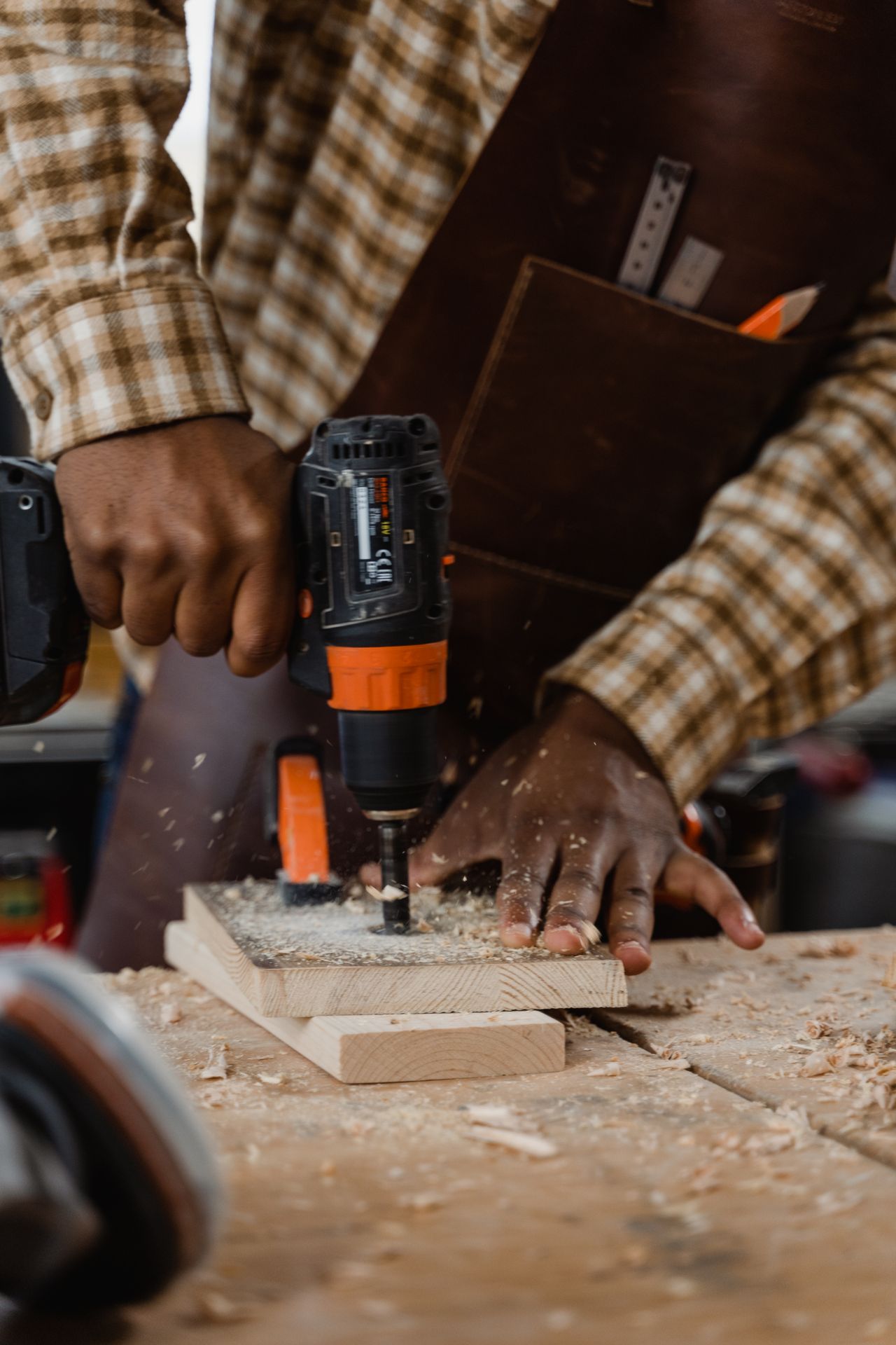 Carpenter working timber with a drill